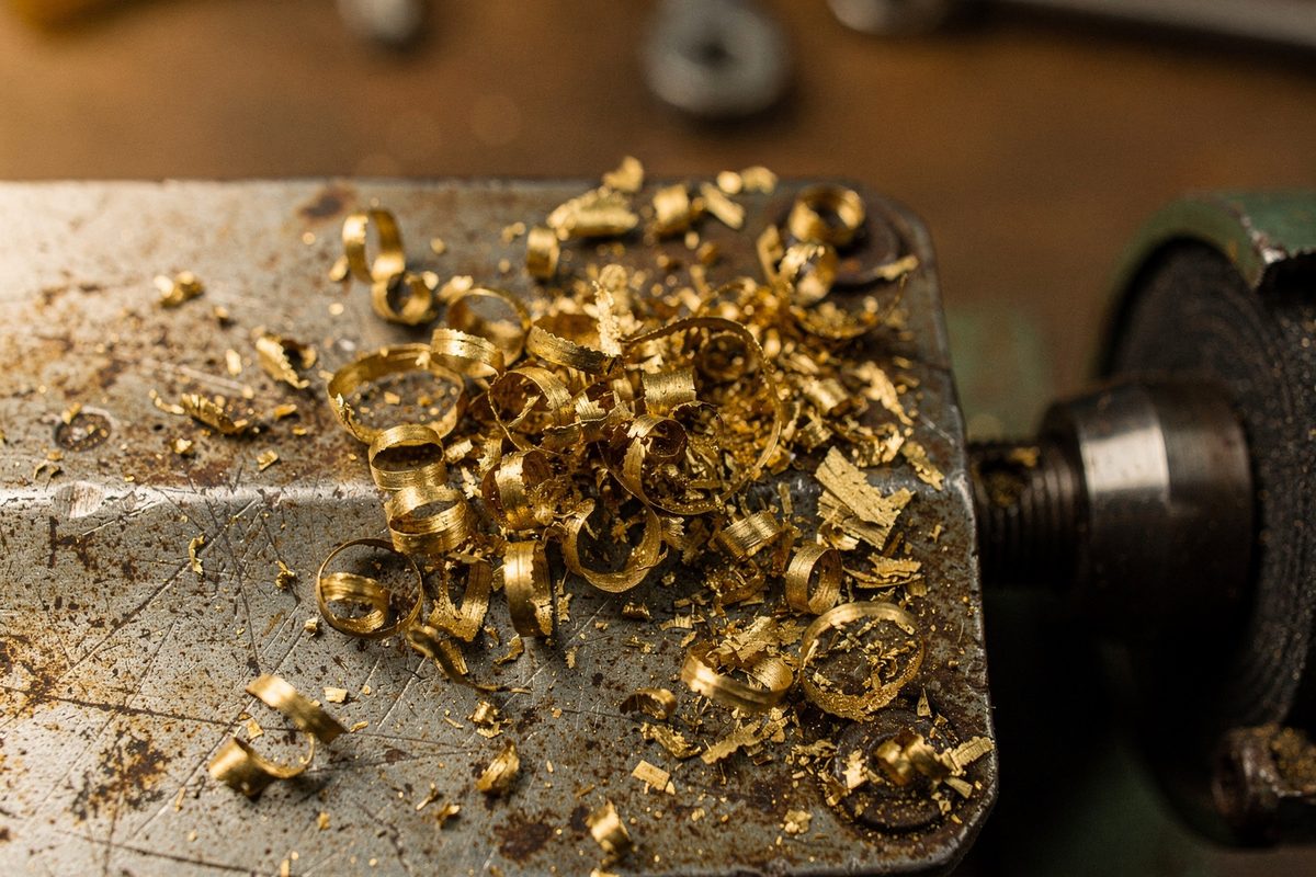 Curled brass shavings scattered on a steel key-cutting machine plate